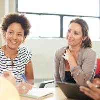 Teachers at a round table in discussion with one another