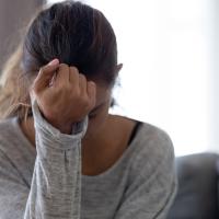 Teen girl looking down into her hand while sitting