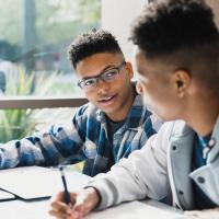 Two boys writing beside one another