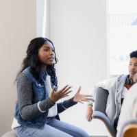 Young woman explaining her ideas to a group.