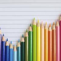 A bar graph made of colored pencils shows fluctuations but a general uptrend