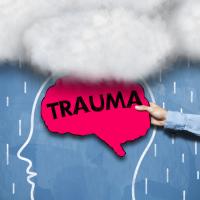 Outline of a head with clouds above it and a hot pink brain with the word TRAUMA written across it