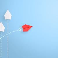 3 white paper airplanes heading north and one red paper airplane veering right